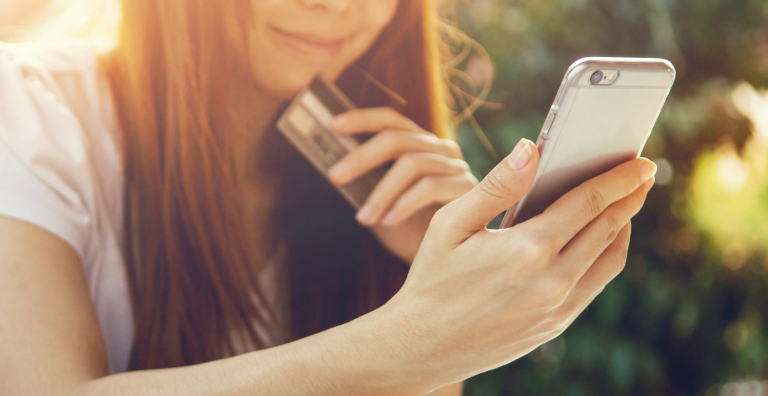 woman holding smartphone and credit card