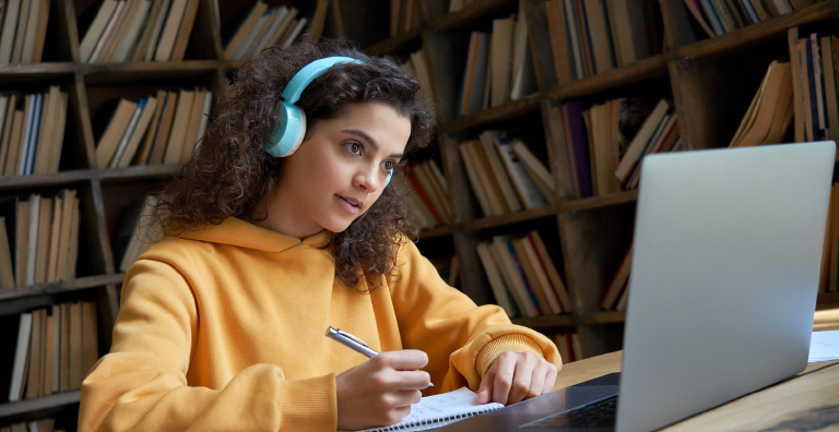 Young woman wearing headphone looking at computer screen