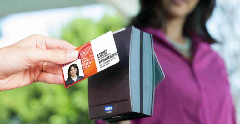 Person hält personalisierten Ausweis über HID Lesegerät