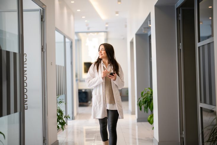 person walking through office holding phone