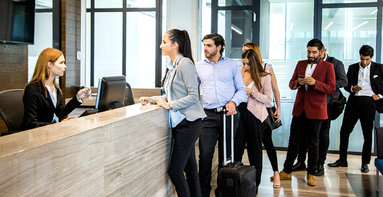 Guests waiting in line at a reception desk due to an inefficient hotel check-in system.