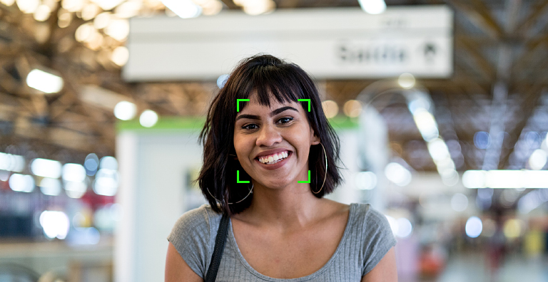 Smiling woman with facial biometrics scan overlay for secure identity verification at airport.