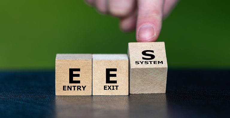 Wooden blocks showing entry/exit system concept, symbolizing European Union EES, biometric border control.